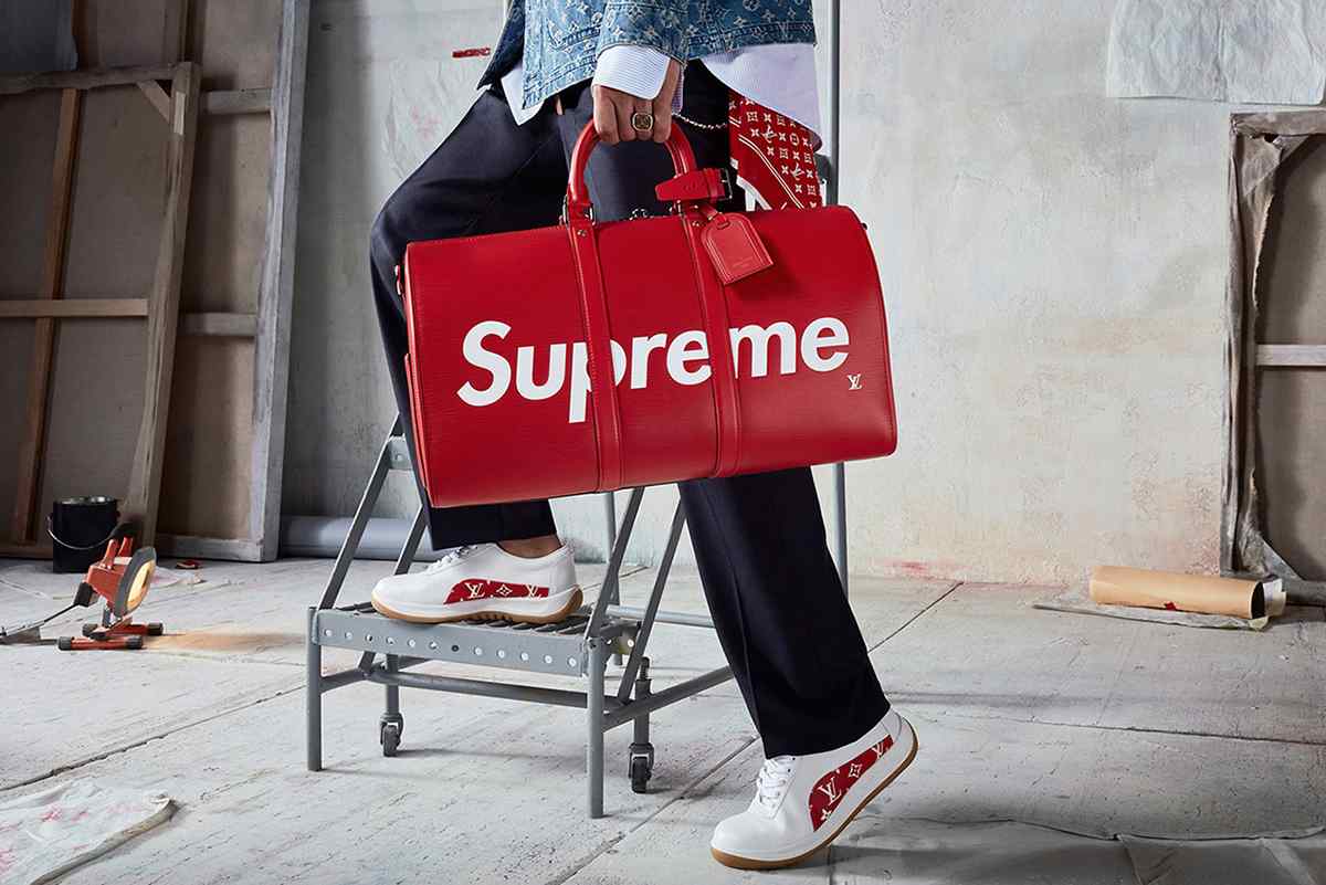 Supreme and Louis Vuitton brand collaboration featuring red duffle bag and sneakers