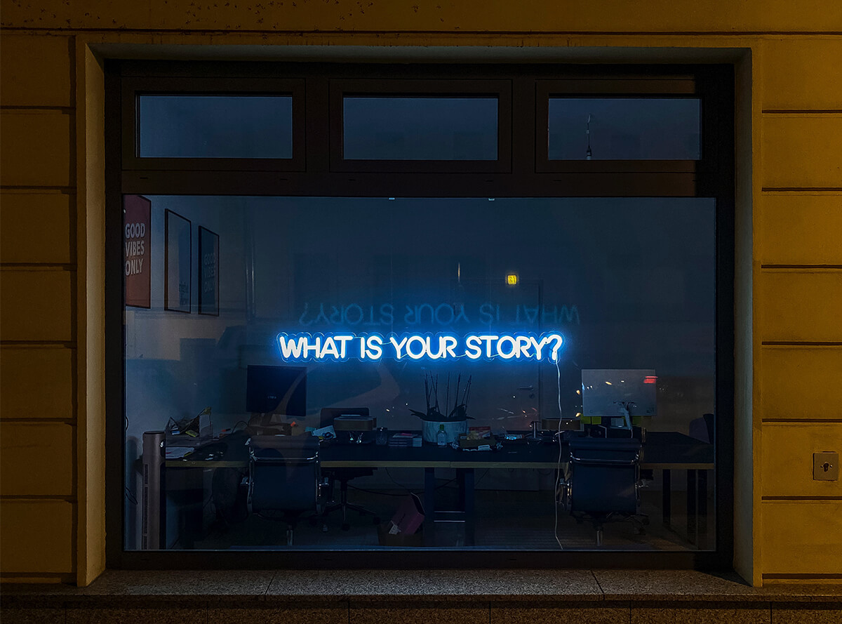 Neon sign asking "What is your story?" for brand content marketing