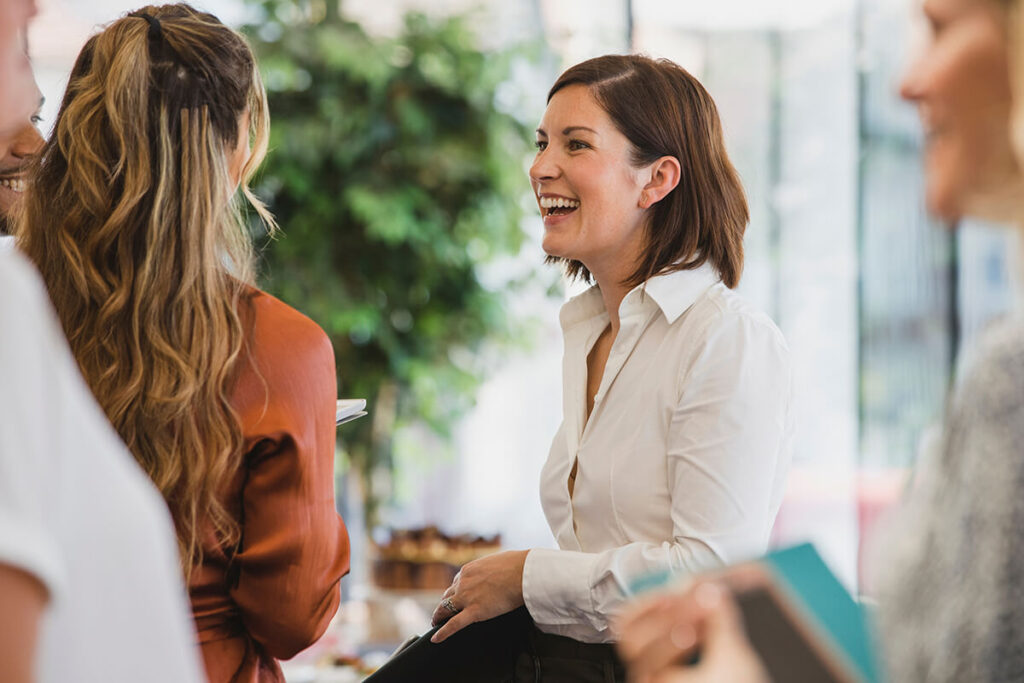 Content marketing for brands through networking and communication. Smiling business woman in conversation with her peers.