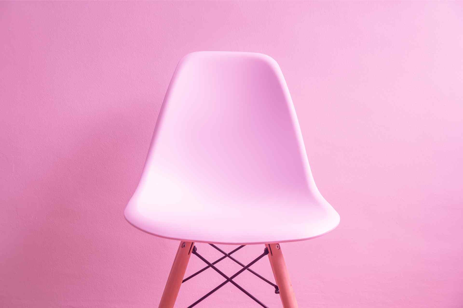 Modern pink chair against a pink background, symbolizing the start of a customer's journey.