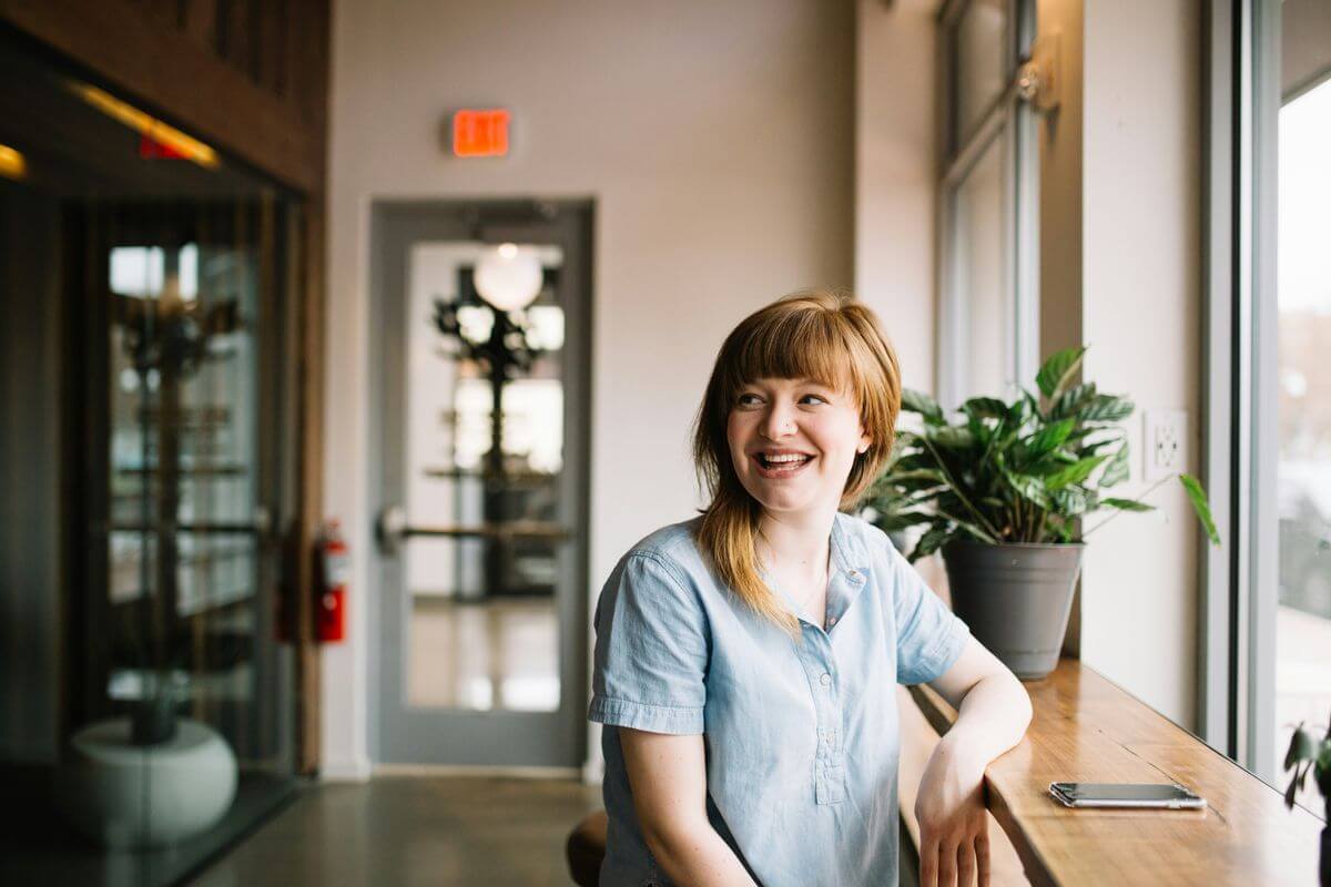 Smiling woman in casual attire, representing a satisfied participant in a referral program