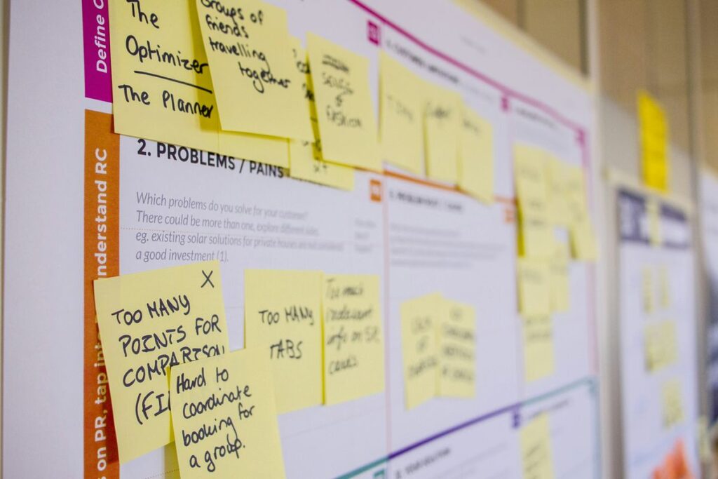 Sticky notes on a board outlining problems and solutions during digital product design process.